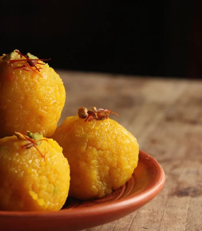 Freshly shaped laddoos topped with saffron