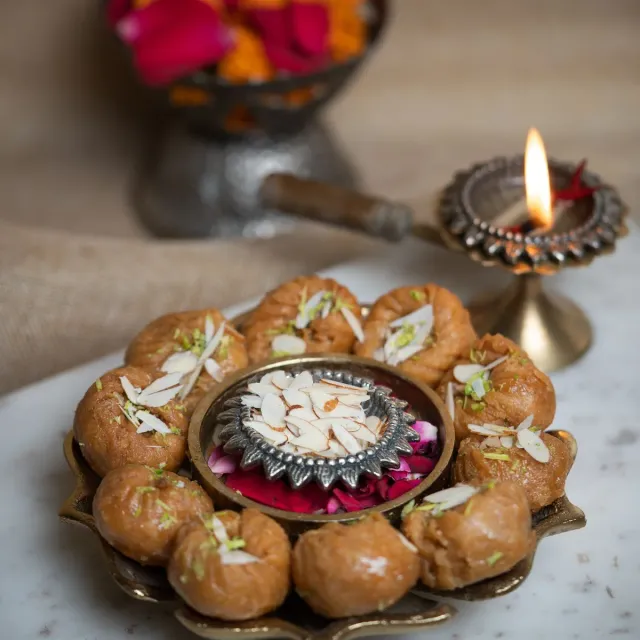 A ring of glazed balushahi on a brass platter