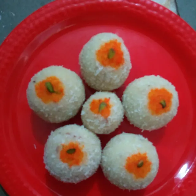 White malai laddoos topped with saffron and pistachio on a plate