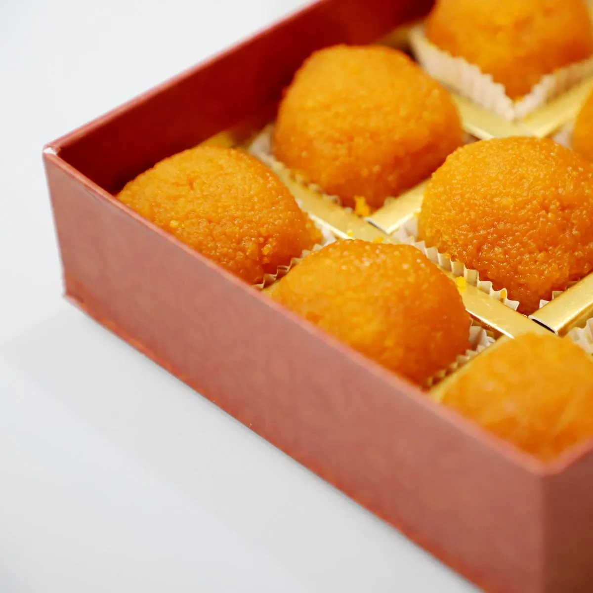 An open gift box of saffron laddoos