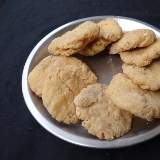 स्टील की प्लेट में खस्ता सुनहरी मठरी